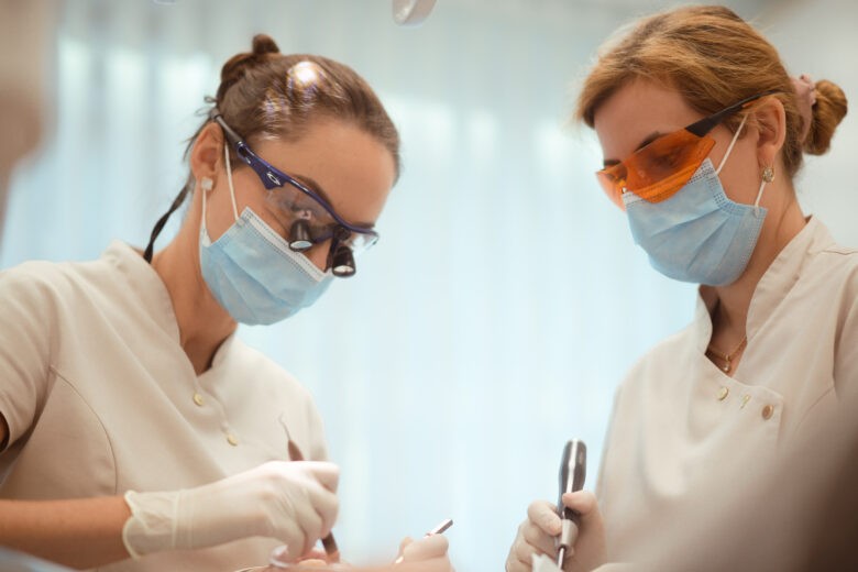 dvi odontologes dirba irankiais